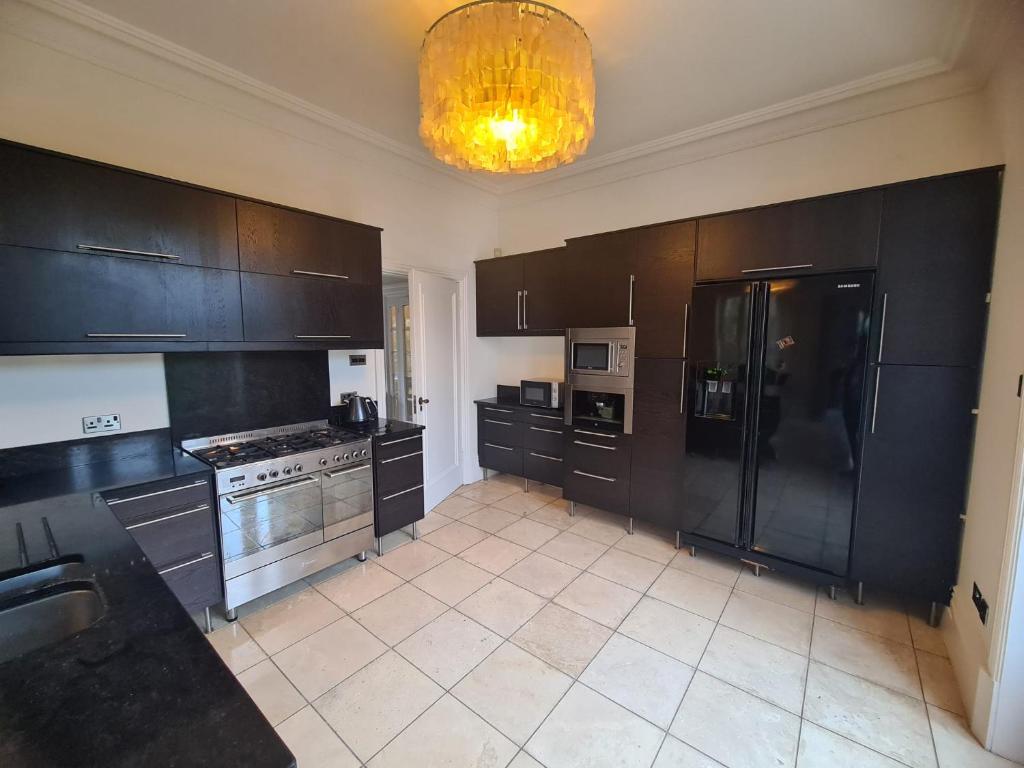 a kitchen with black cabinets and stainless steel appliances at 23 HeadsLane in Hessle