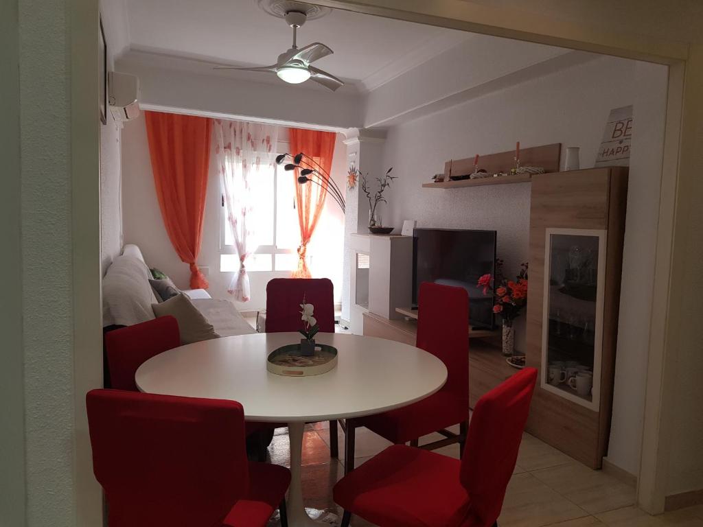 un soggiorno con tavolo e sedie rosse di BRIZO SUITES a Grao de Castellón