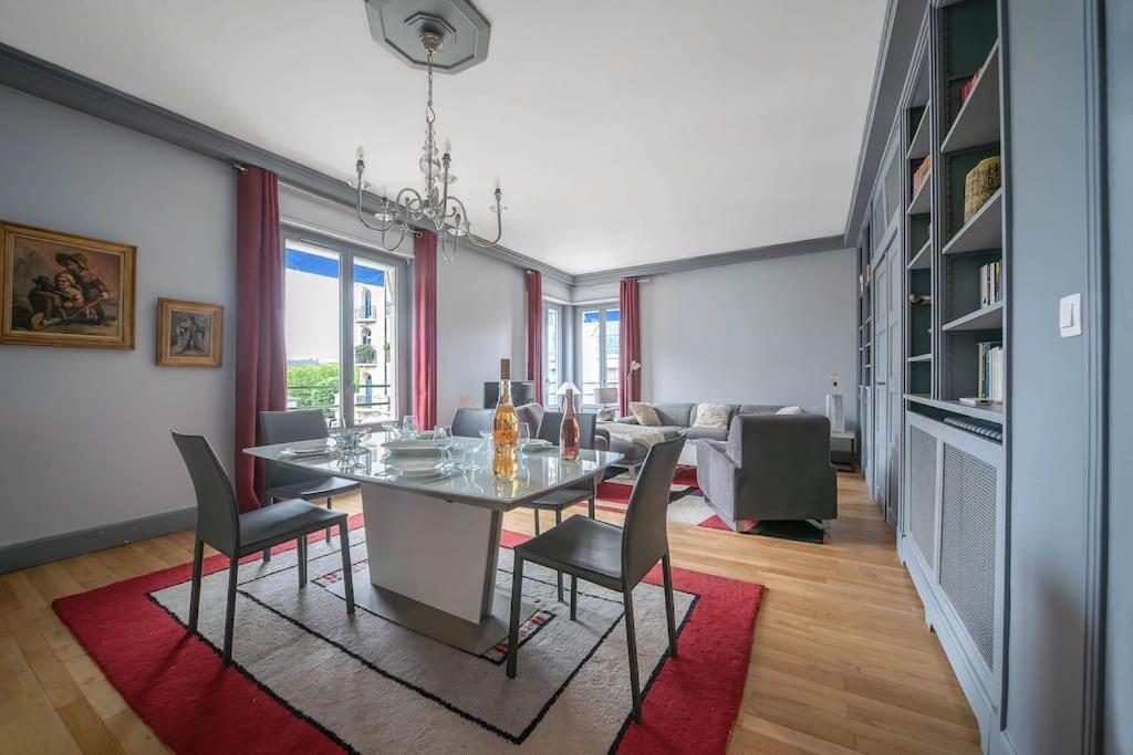 een eetkamer met een tafel, stoelen en een bank bij L'ANTHRACITE - Proche Opéra & Centre-ville in Vichy