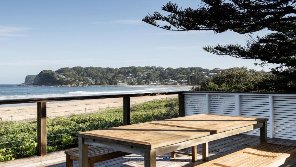 a picnic table on a deck overlooking the beach at Beachfront at Avoca North in North Avoca