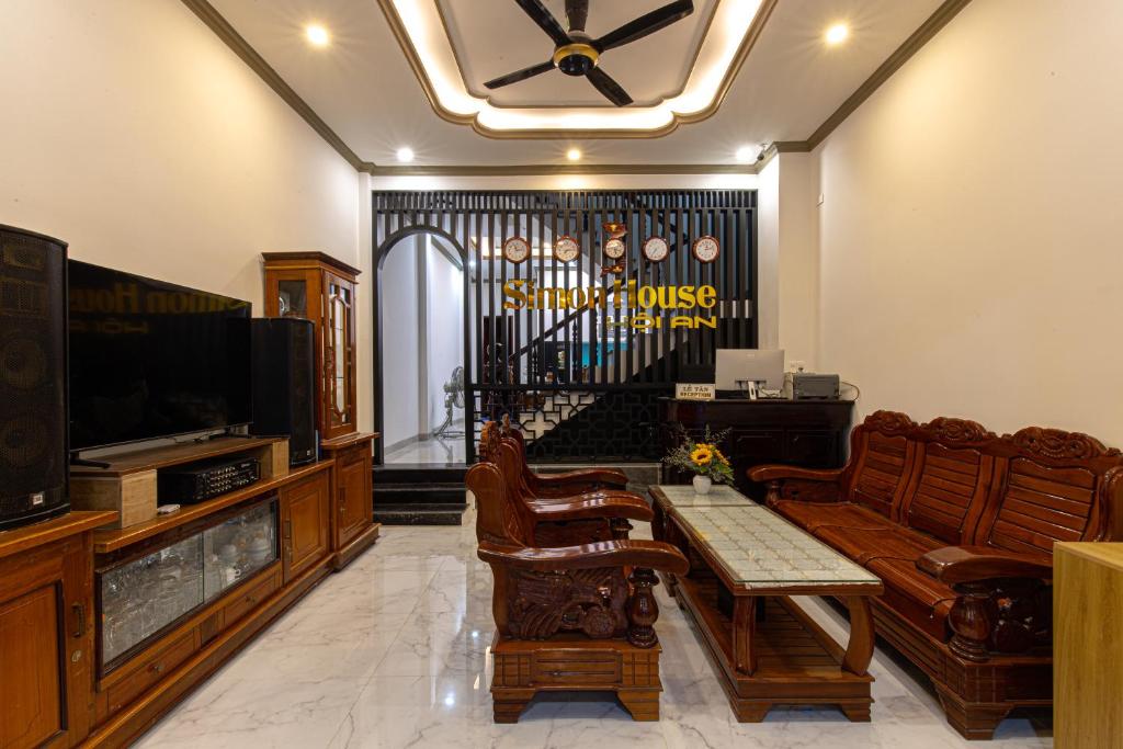 - un salon avec un canapé et une télévision dans l'établissement Simon House Hoi An, à Hội An