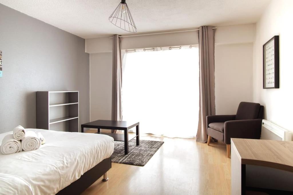 une chambre avec un lit, une chaise et une fenêtre dans l'établissement Obernai - Studio agréable avec balcon - Proche gare, à Strasbourg