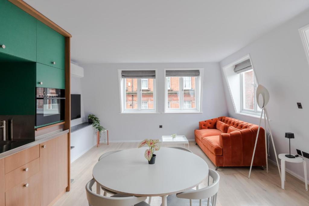 een woonkamer met een witte tafel en een bank bij Casa Emilio - Soho - by Frankie Says in Londen