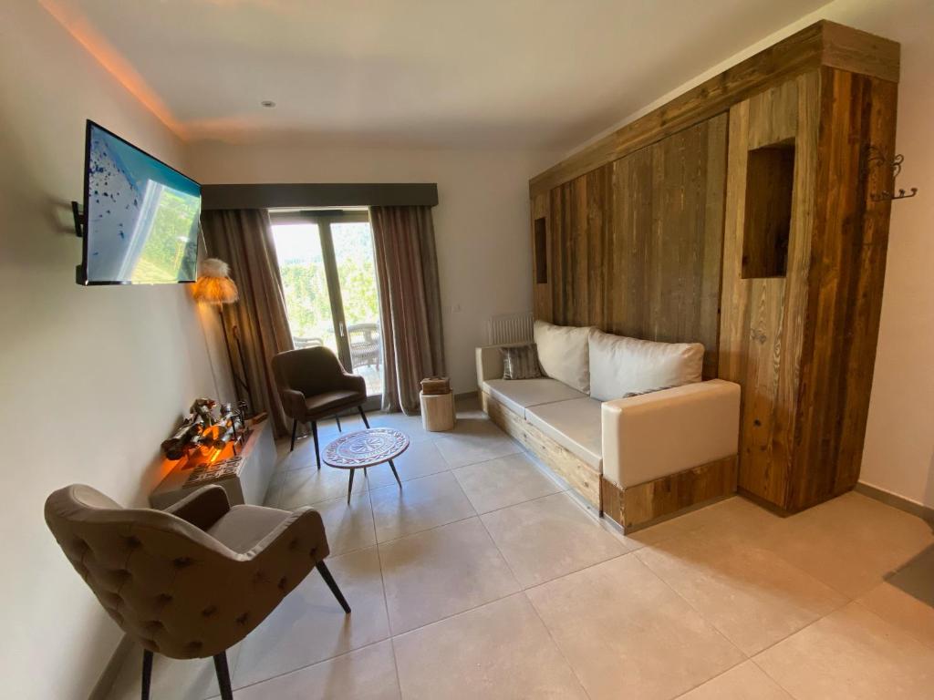 a living room with a couch and a chair at Les Trois Chaufatons - Chalets Boutiques in Montriond