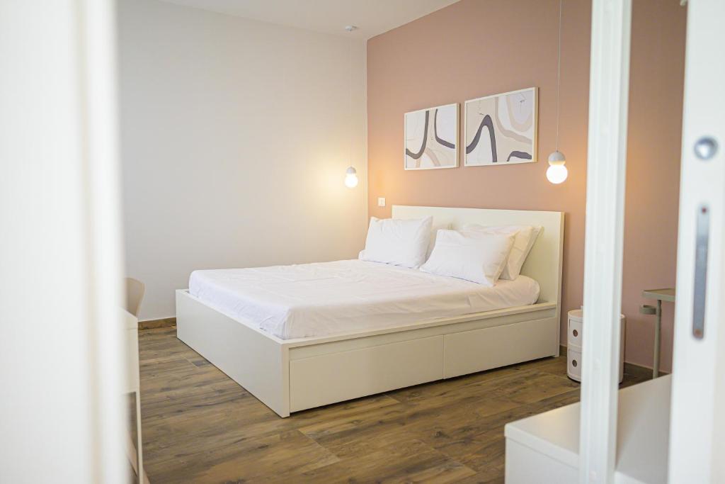 1 dormitorio con 1 cama con sábanas blancas y almohadas blancas en Piccolo Torino Rooms, en Canicattì