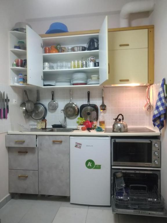a small kitchen with white cabinets and a dishwasher at Loutraki-SPA-Apartment in Loutraki
