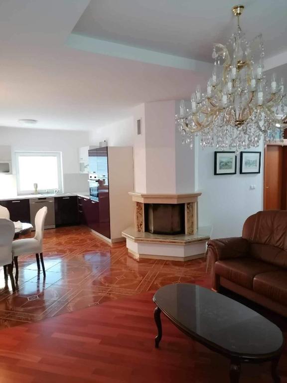 a living room with a couch and a table and a chandelier at Apartma Bistrica in Slovenska Bistrica
