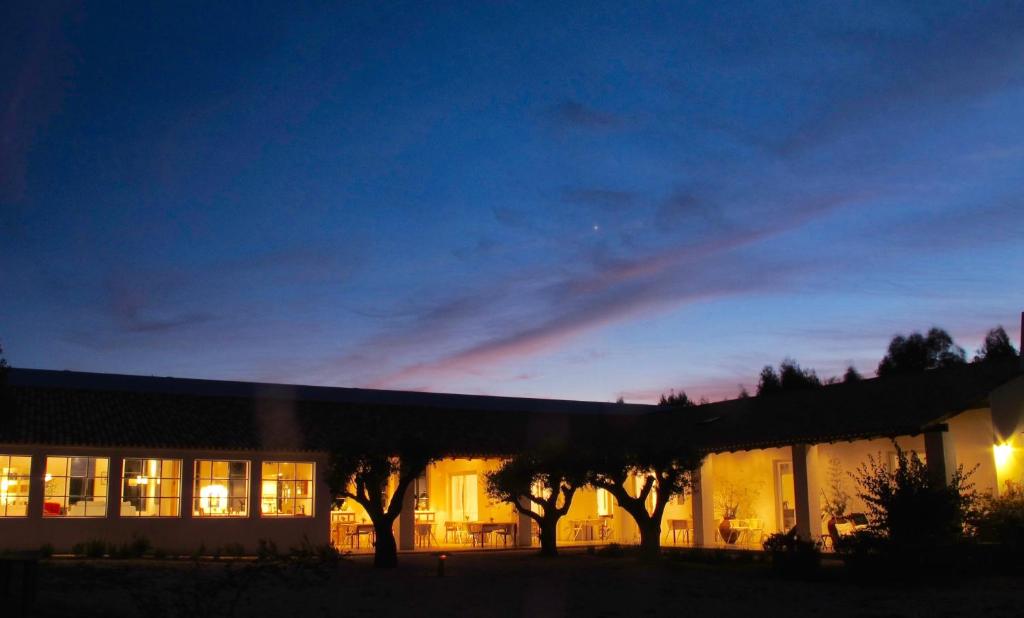 un bâtiment avec des arbres devant lui la nuit dans l'établissement Tres Marias, à Vila Nova de Milfontes