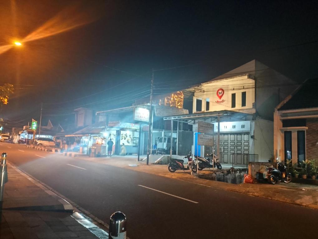 ulica miejska w nocy z motocyklem zaparkowanym obok budynku w obiekcie Homestay Kamal w mieście Padangpanjang