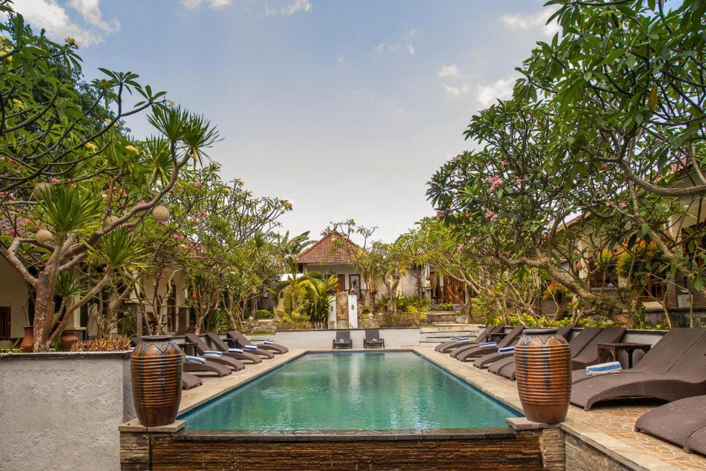 a swimming pool in a resort with lounge chairs at Tropical Garden by TANIS in Nusa Lembongan