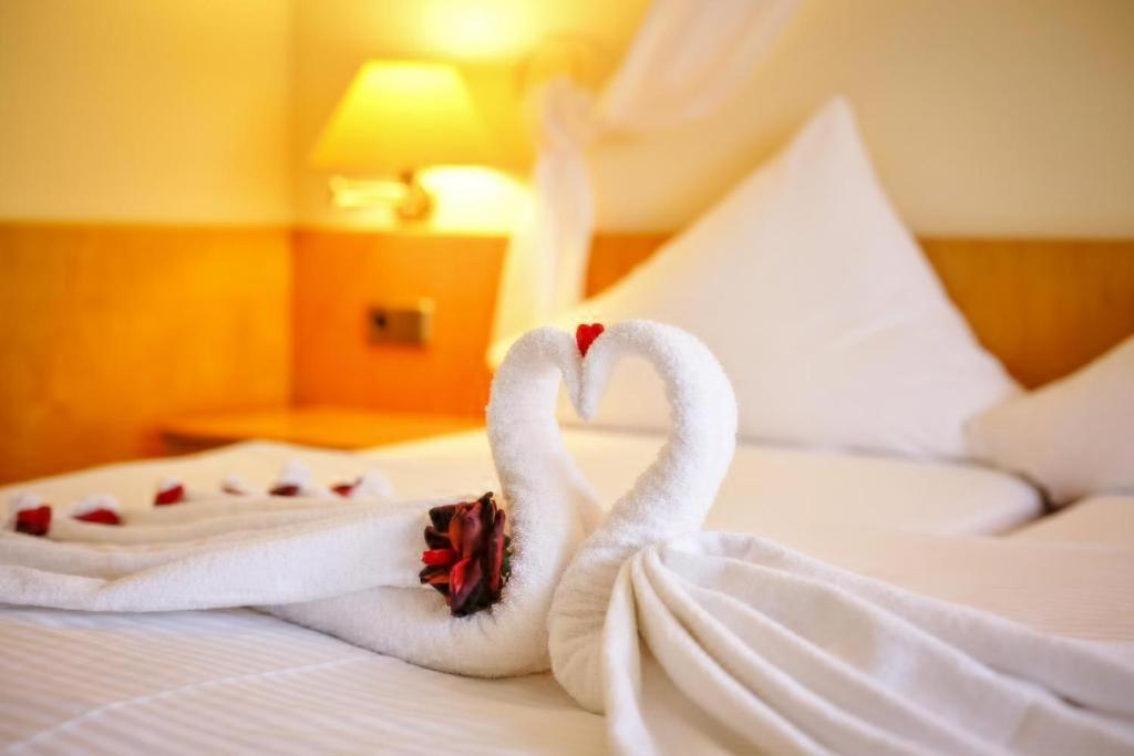 two swans wrapped in towels sitting on a bed at Hotel und Restaurant Harzparadies in Harztor