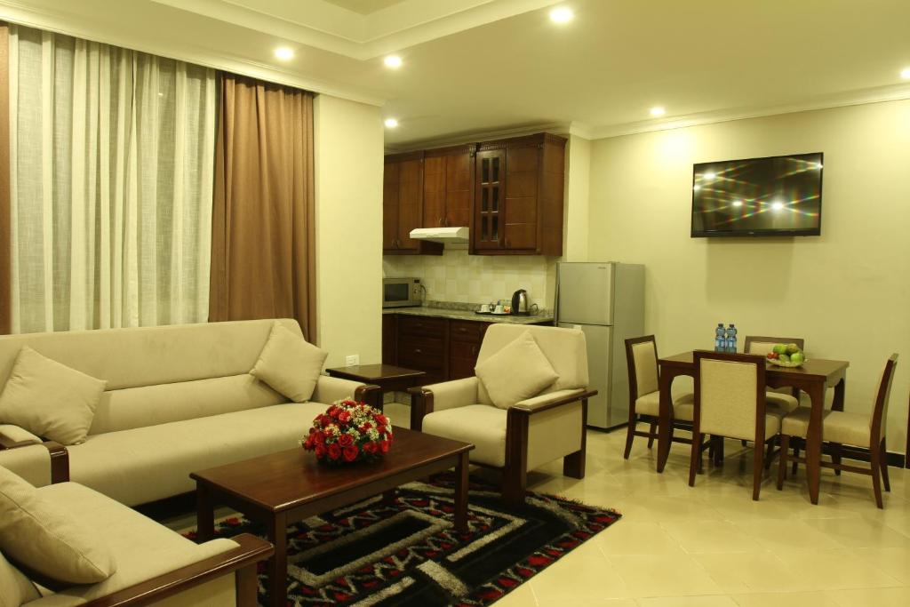a living room with a couch and a table and a kitchen at Geza Apartment Hotel in Addis Ababa