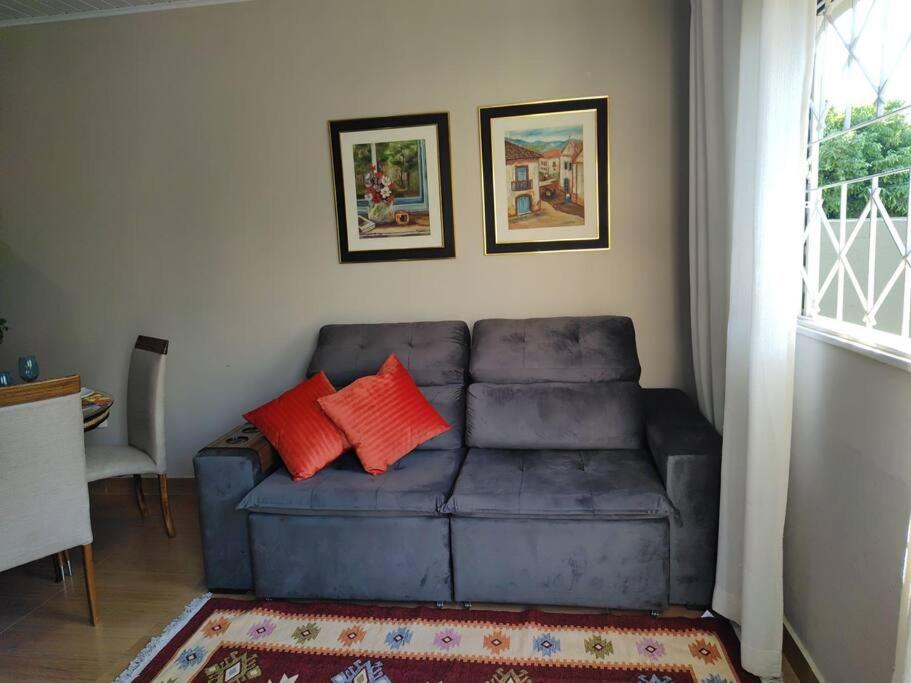 uma sala de estar com um sofá azul com duas almofadas vermelhas em Casa aconchegante em São José do Rio Preto