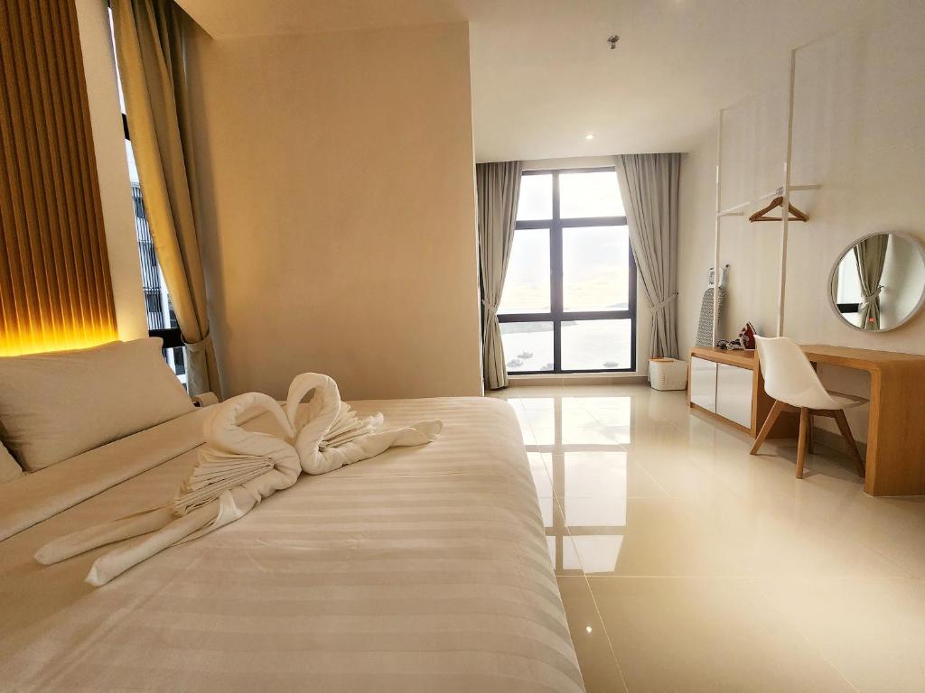 a bedroom with a bed with a towel on it at The Shore Kota Kinabalu City Centre by LW Suites in Kota Kinabalu