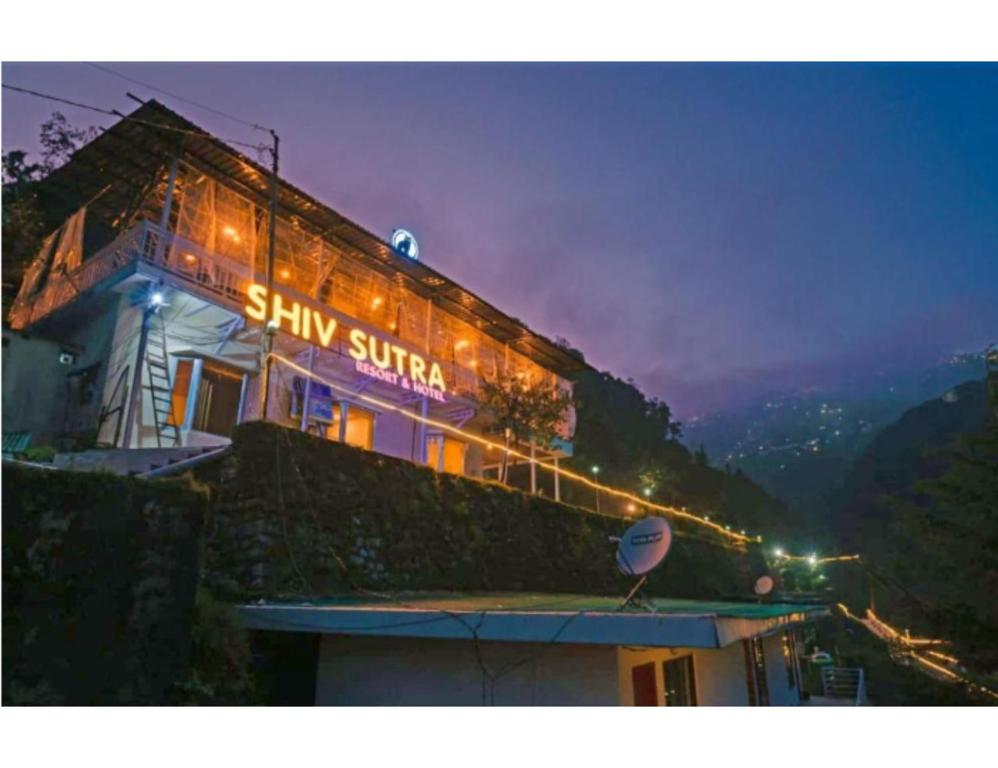 un bâtiment avec un panneau la nuit dans l'établissement Shiv Sutra Resorts, Mussoorie, à Mussoorie