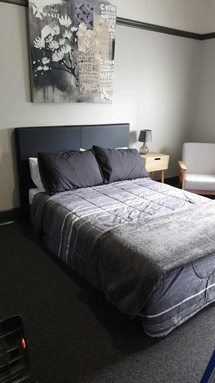 Un dormitorio con una cama y una mesa con una silla. en Club Hotel Warragul, en Warragul