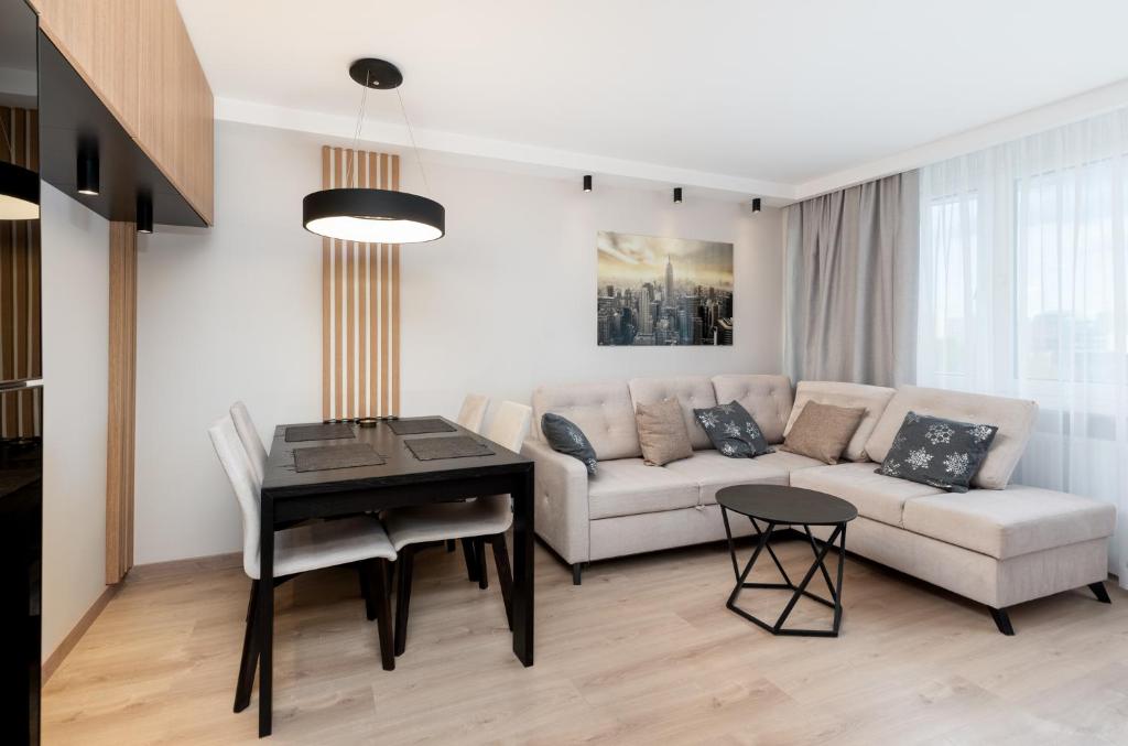 uma sala de estar com um sofá e uma mesa em Bronowice Cosy Apartment em Cracóvia