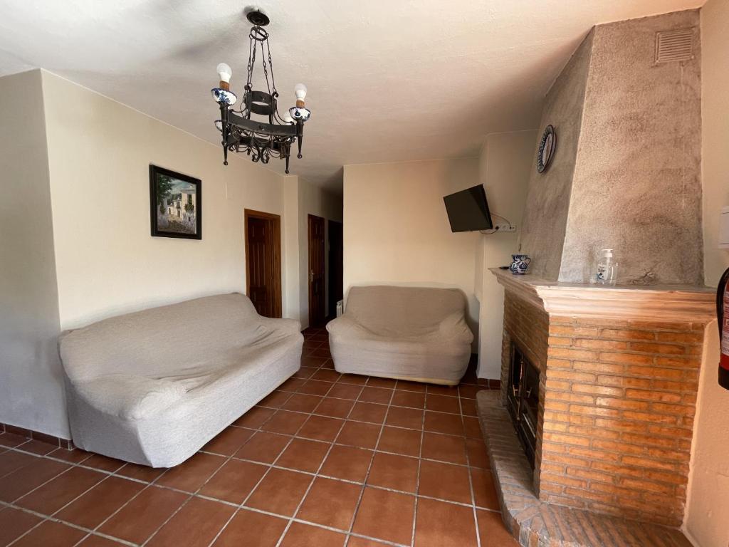 sala de estar con sofá y chimenea en Apartamentos Rurales Las Chimeneas, en Capileira