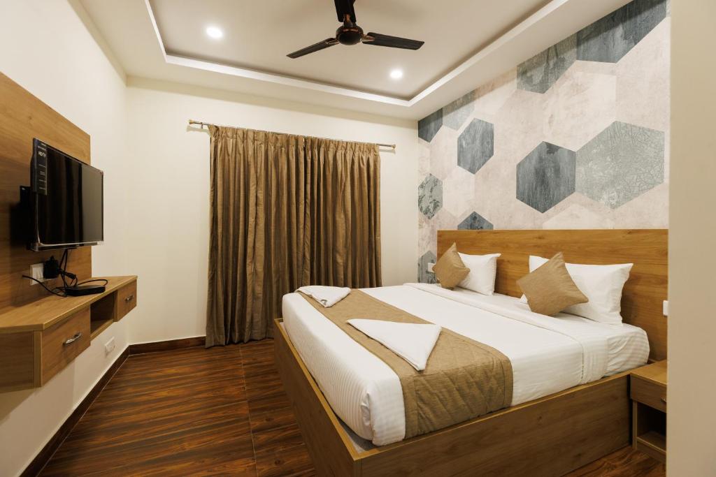 a bedroom with a bed and a flat screen tv at V V Grand in Chennai