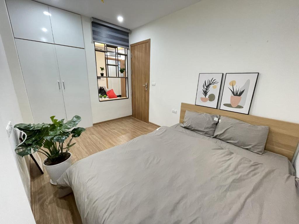 sypialnia z łóżkiem i doniczką w obiekcie Funhome Apartment Kim Ma Ha Noi w mieście Hanoi