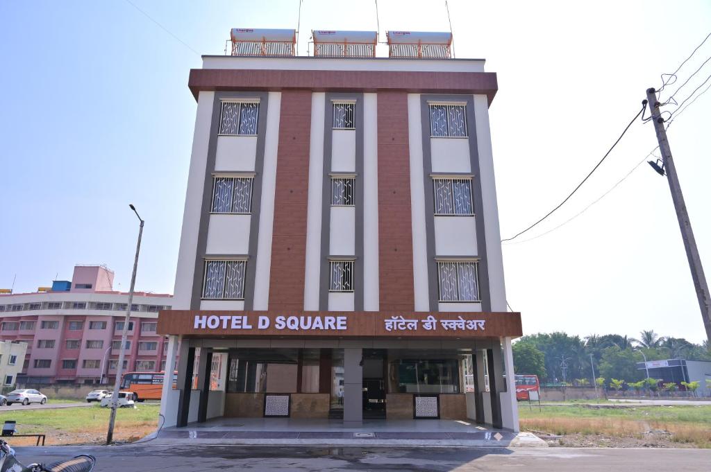 a building with a clock tower on top of it at HOTEL D SQUARE . in Shirdi