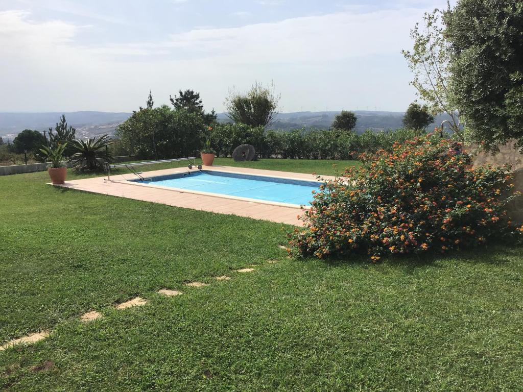 a swimming pool in the yard of a house at The Garden Room in Bombarral