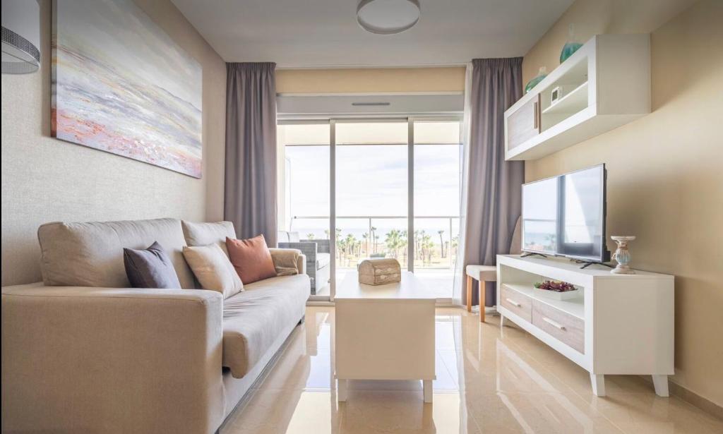 sala de estar con sofá y TV en CASA AMANECER 1ªLinea de Playa Familiar, en Castellón de la Plana