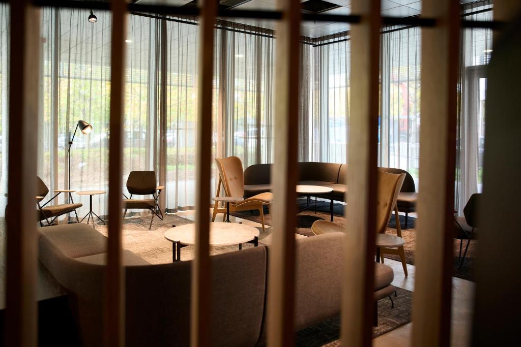 een kamer met een tafel, stoelen en ramen bij Zleep Hotel Hillerød in Hillerød