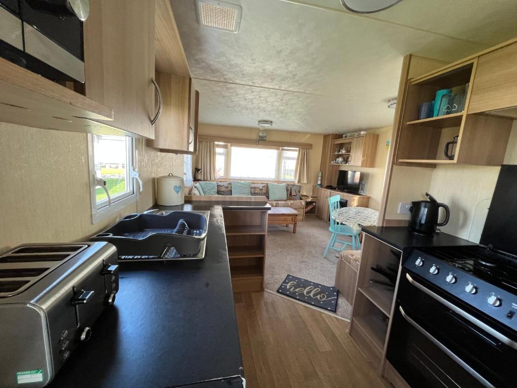a kitchen and living room of an rv at Eagle 4a, Scratby - California Cliffs, Parkdean, sleeps 8, bed linen and towels included, pet friendly and close to the beach in Great Yarmouth