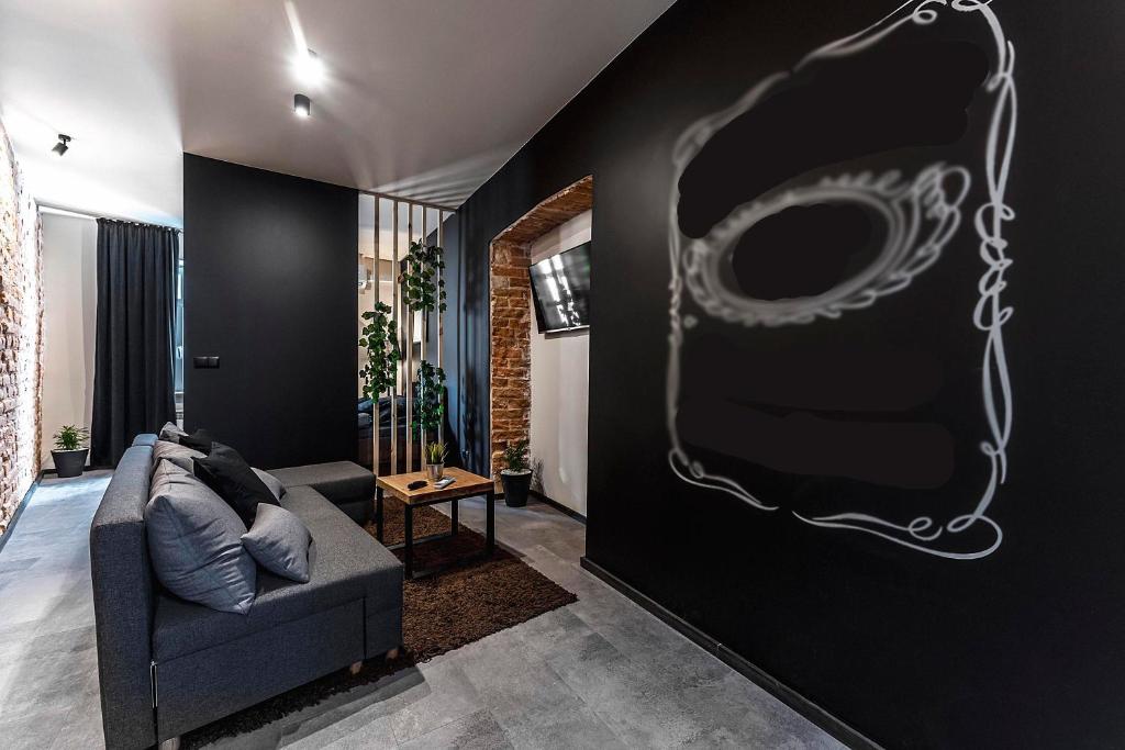 a living room with a couch against a black wall at Krakowskie30 Loft1 deptak in Lublin