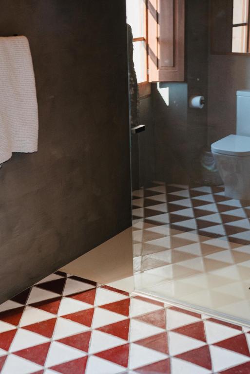 a bathroom with a checkered floor and a toilet at Hotel-Masia Can Farrés in El Bruc