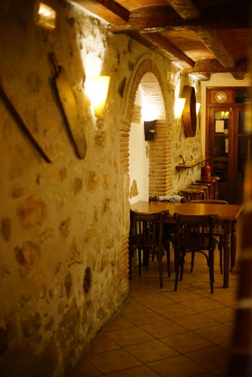 L'Hostalet في Arboli: مطعم بطاولات وكراسي بجدار حجري