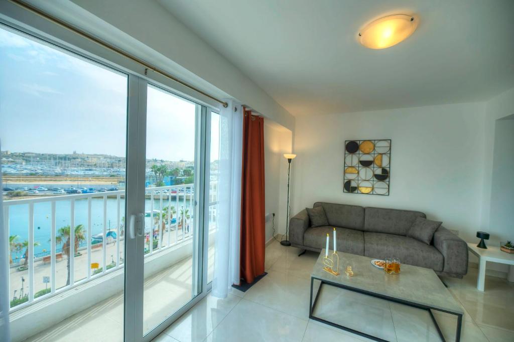 a living room with a couch and a large window at Seafront bright & spacious 2 bedrooms GOGZR-1 in Il-Gżira