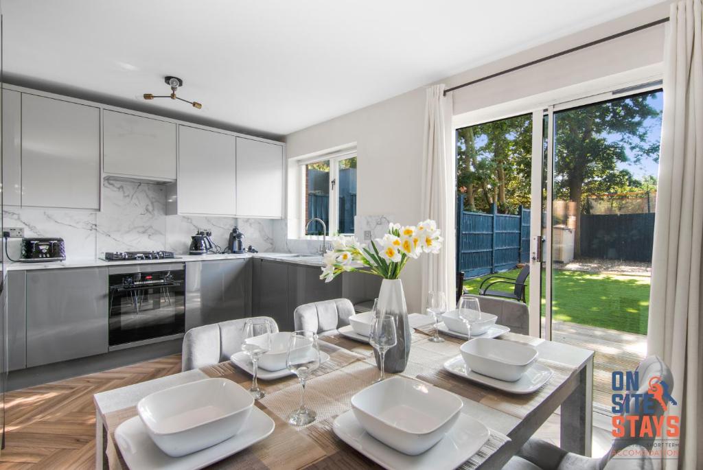 a kitchen and dining room with a table and chairs at OnSiteStays - EARLY CHECK IN MAY - Modern 3 bed House, 2 x Parking, Garden, WIFI & dishwasher in Bromley