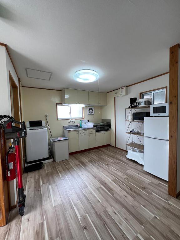 那覇市にある駅徒歩２分の貸切一軒家【Villa Kokusai】の広い客室で、キッチン(白い電化製品付)が備わります。