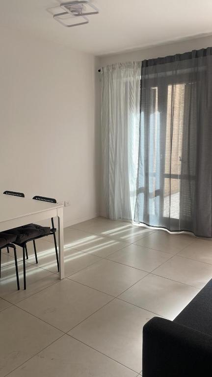 ein Wohnzimmer mit einem weißen Tisch und einem Fenster in der Unterkunft Appartamento viale della stazione in Spoleto