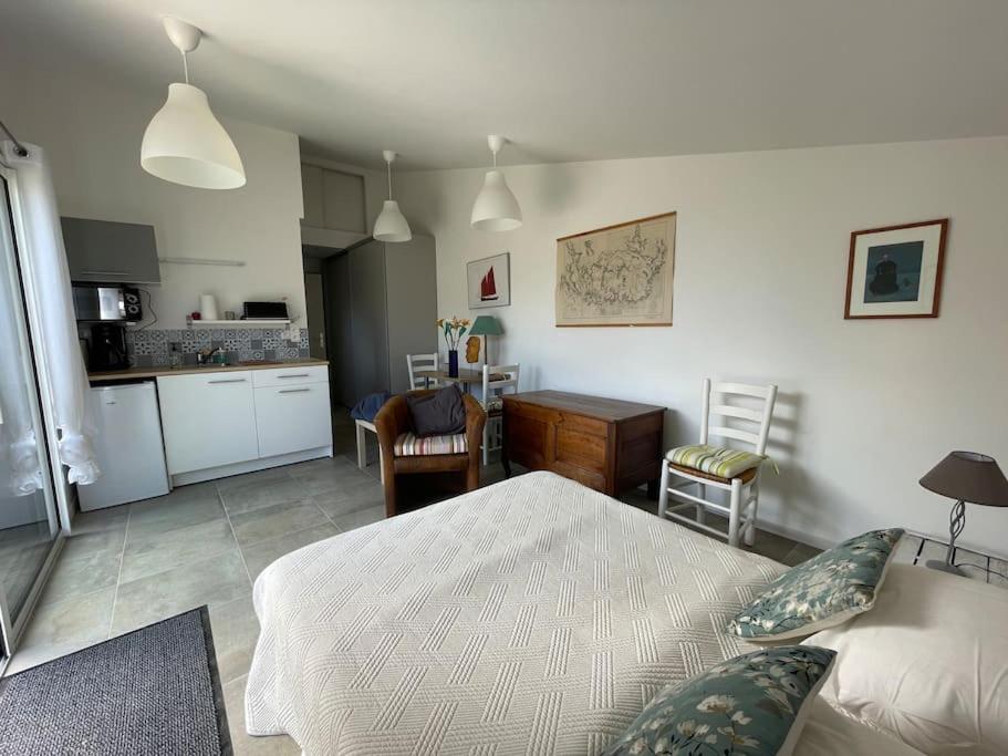 un salon avec un lit et une cuisine dans l'établissement Studio au calme avec jardin et stationnement, à Vannes