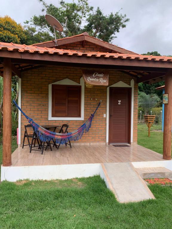 un patio con una hamaca y una casa en Chalé Quartzo no Recanto Diamantina entre Palmeiras e Capão en Palmeiras