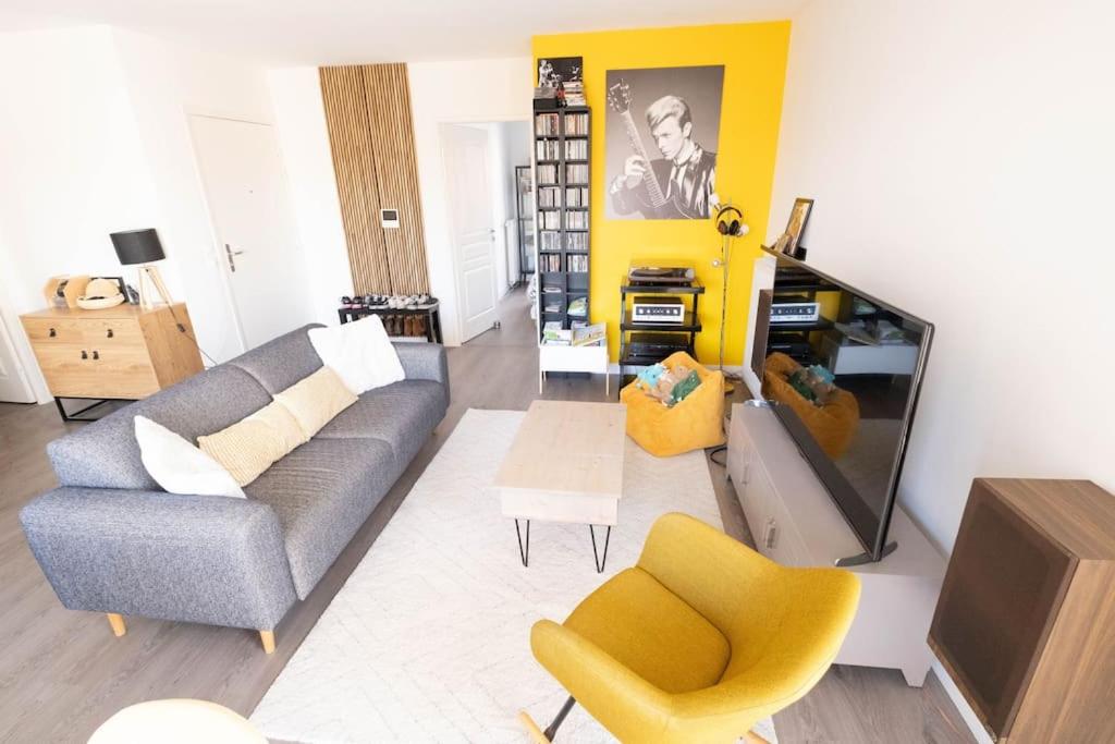 - un salon avec un canapé et une télévision dans l'établissement Appartement lumineux 4P/Terrasse, à Saint-Ouen