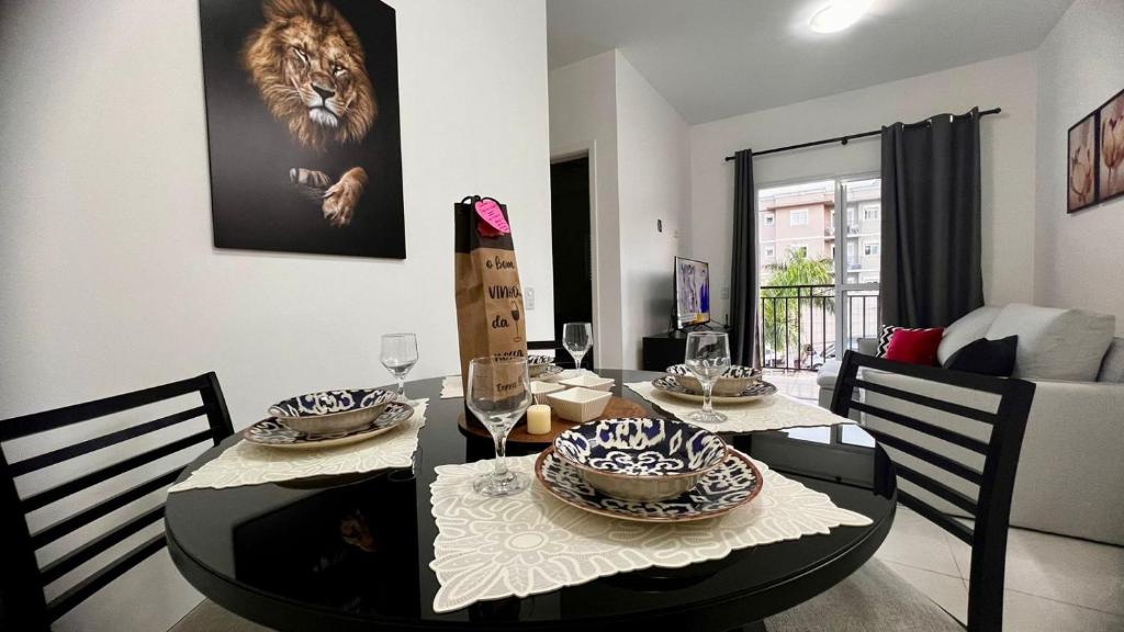 a dining room with a table with a lion picture on the wall at Apto próximo ao roteiro do vinho in São Roque
