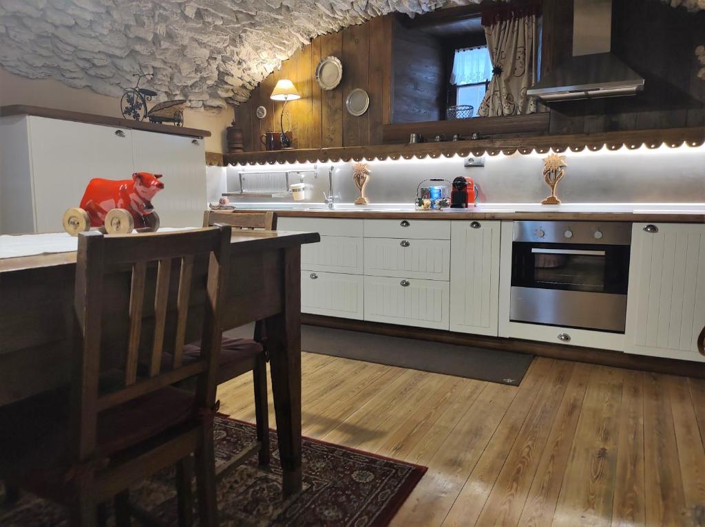 kuchnia z białymi szafkami, stołem i kuchenką w obiekcie Le Petit Château de Vetan CIR 0023 w mieście Saint-Pierre
