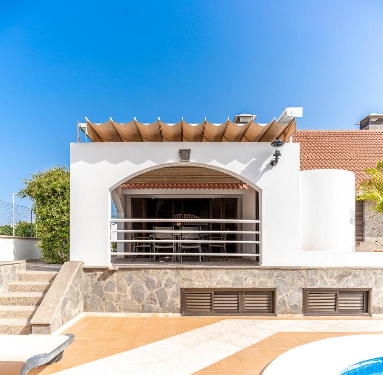 a house with a swimming pool and a patio at Villas Las Almenas in Maspalomas