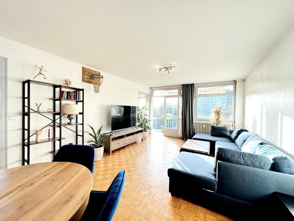 聖朱利安昂熱內瓦的住宿－Le Panorama，客厅配有蓝色的沙发和木桌