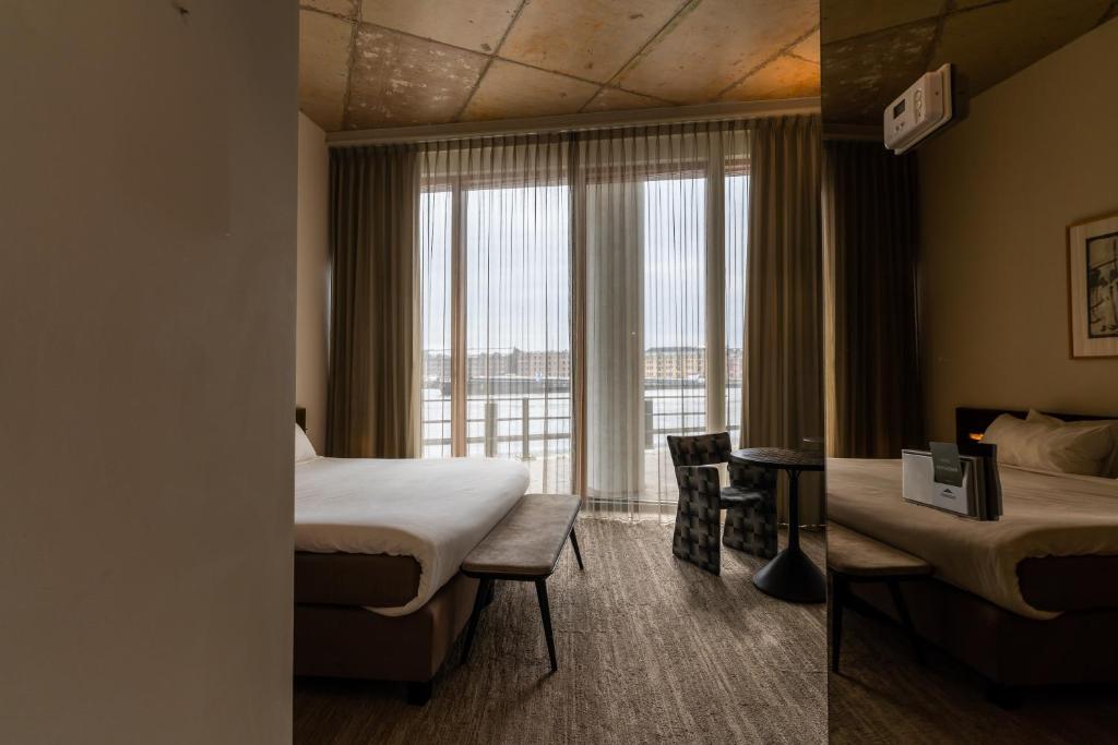 Hotel Pontsteiger في أمستردام: غرفة فندقية بسريرين ونافذة