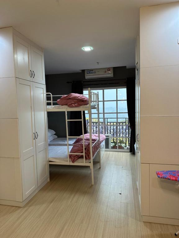 a room with two bunk beds and a balcony at Champs Elysees Homestay by Landmark @ Kampar in Kampar