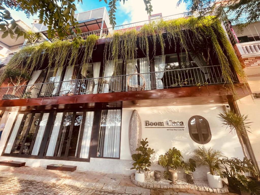 een gebouw met een balkon met planten erop bij Boom Casa Homestay in Hue