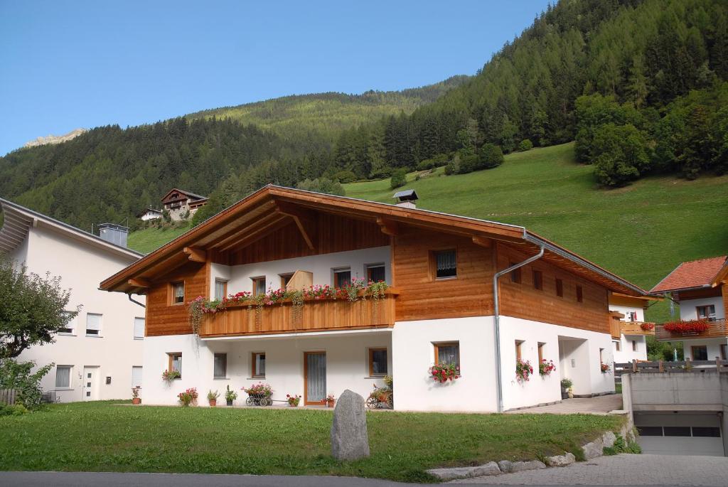 ein Gebäude mit einem Holzdach mit Blumen auf dem Balkon in der Unterkunft Speckign in Steinhaus