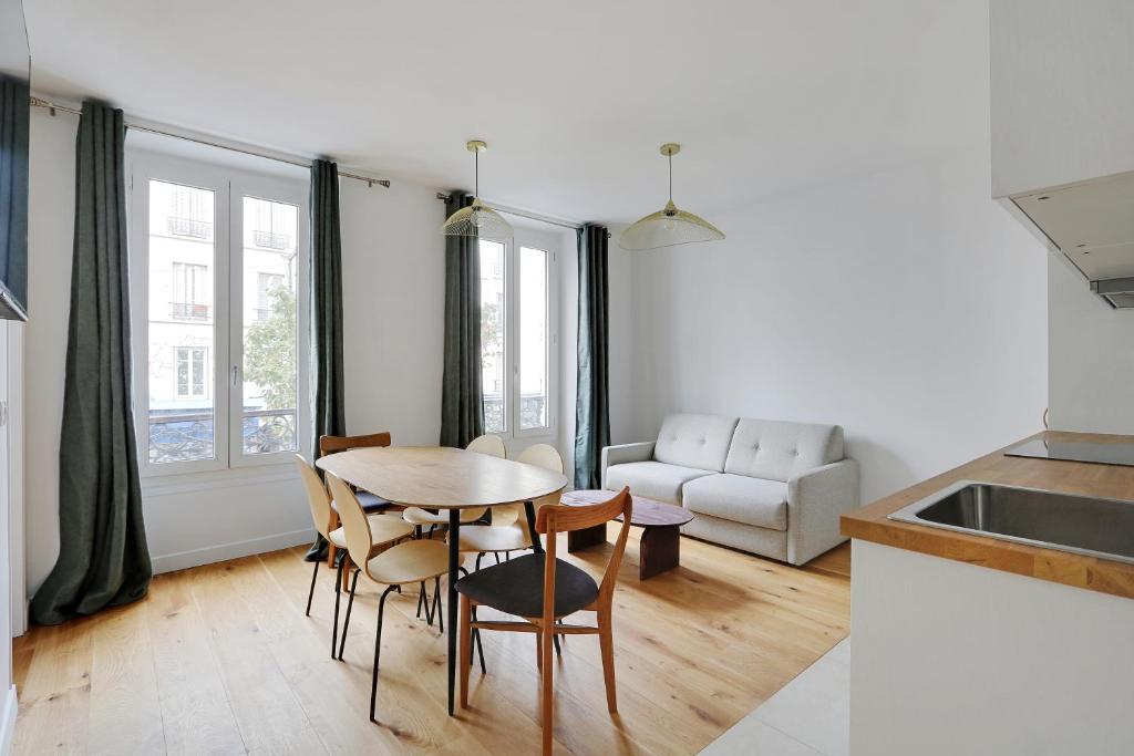 une cuisine et un salon avec une table et des chaises dans l'établissement Pick A Flat's Apartement in Nation - rue d'Avron, à Paris