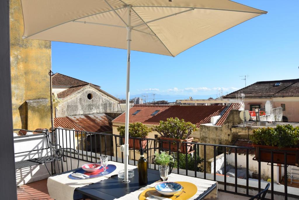 een tafel met een parasol op een balkon bij Volver in Salerno