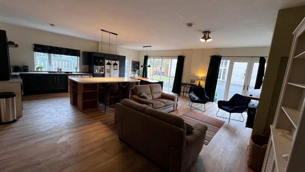uma cozinha e sala de estar com um sofá e uma mesa em Lisnevenagh Cottage em Ballymena
